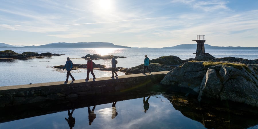 En gruppe seniorer går på sti oppover et fjell