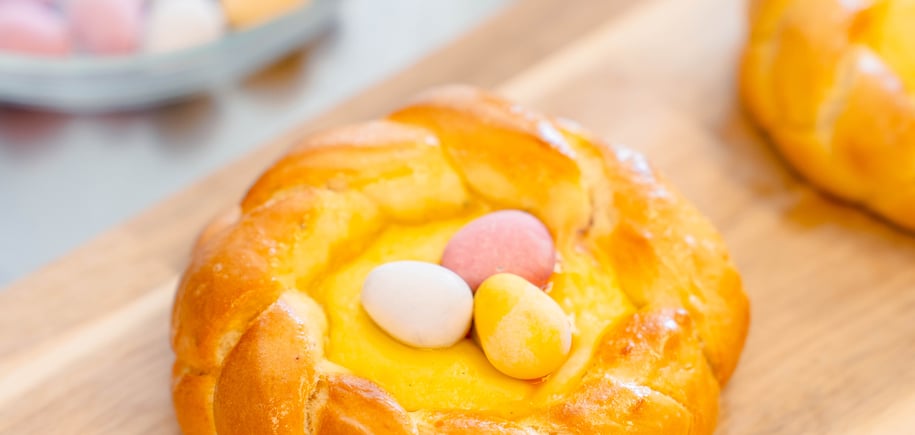 Bilde av en gylden bolle med krem i midten. Den ligger på en trefjøl.