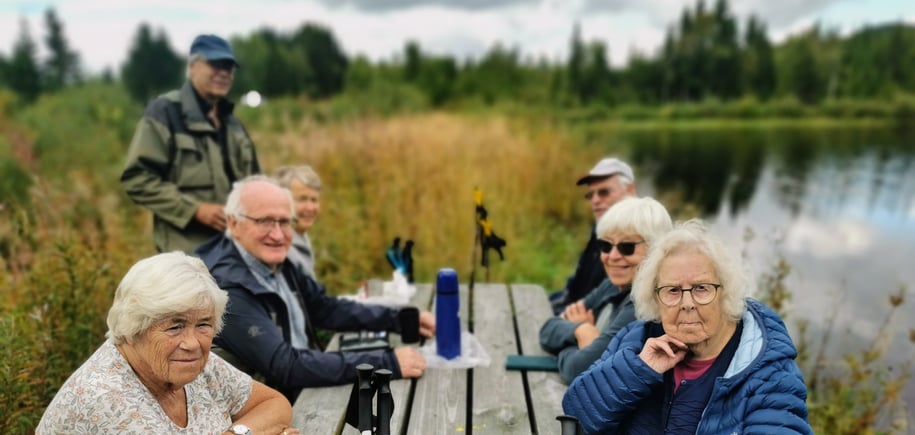 Eldre mennesker sitte på en rastebenk