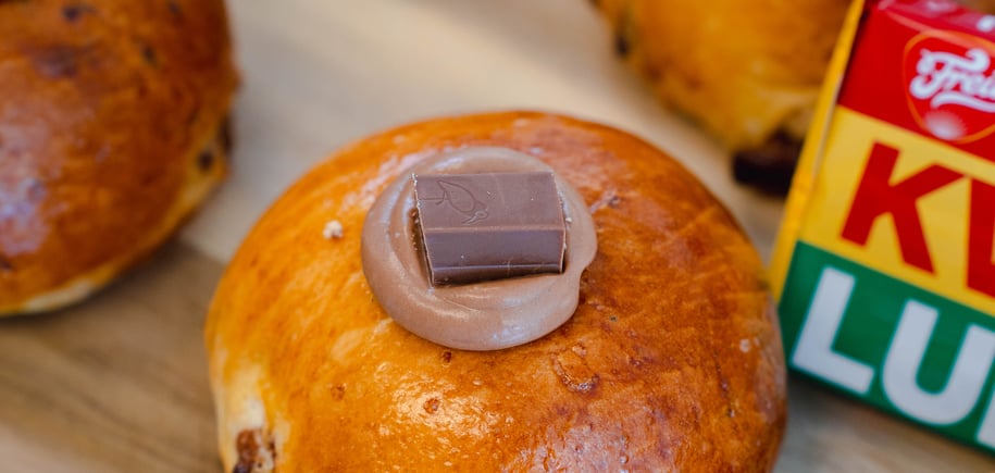 boller toppet med litt sjokoladekrem på toppen, som ligger på en trefjøl. 