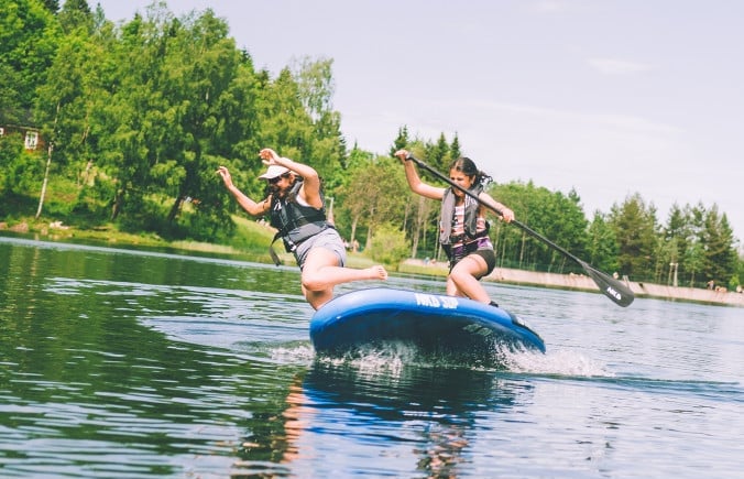 Ungdommer i packraft på stille vann