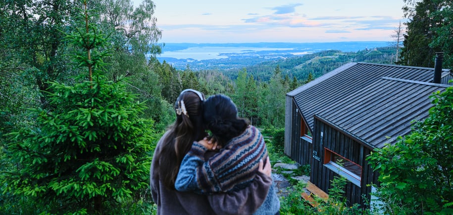 to personer står og se på utsikt ved DNT-hytte