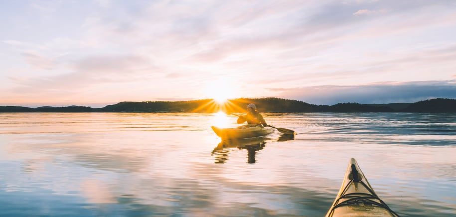 To kajakker på vannet i solnedgang.