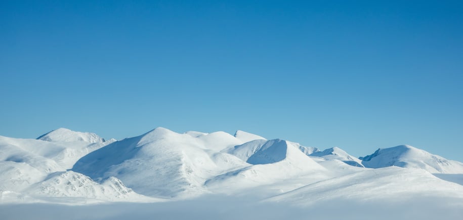 Snødekte fjelltopper og blå himmel
