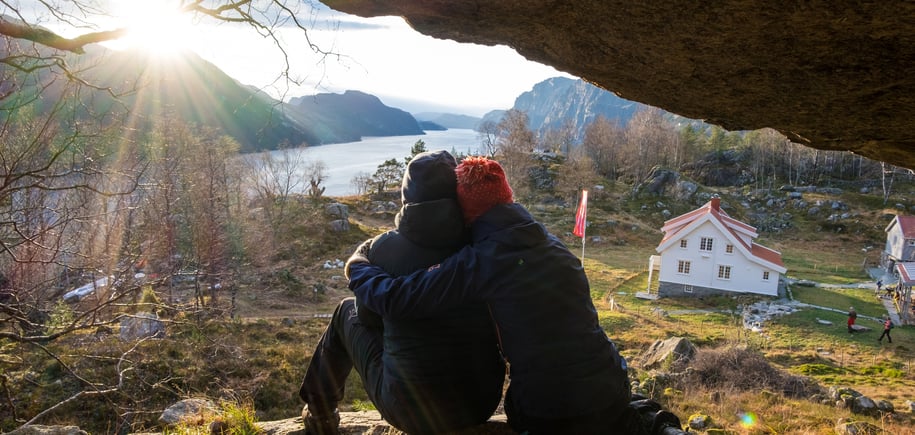 To personer som holder rundt hverandre under en fjellhylle.