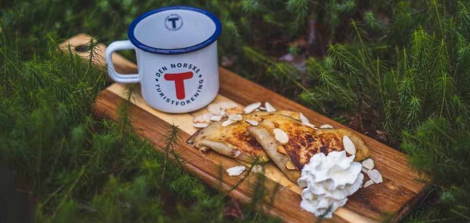 En kopp og to brødskiver som ligger på en skjærefjøl