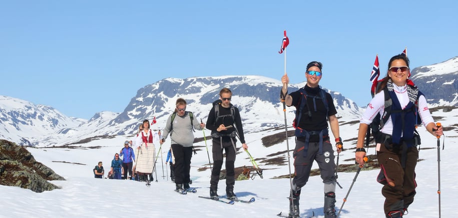 skigåere med bunad og flagg