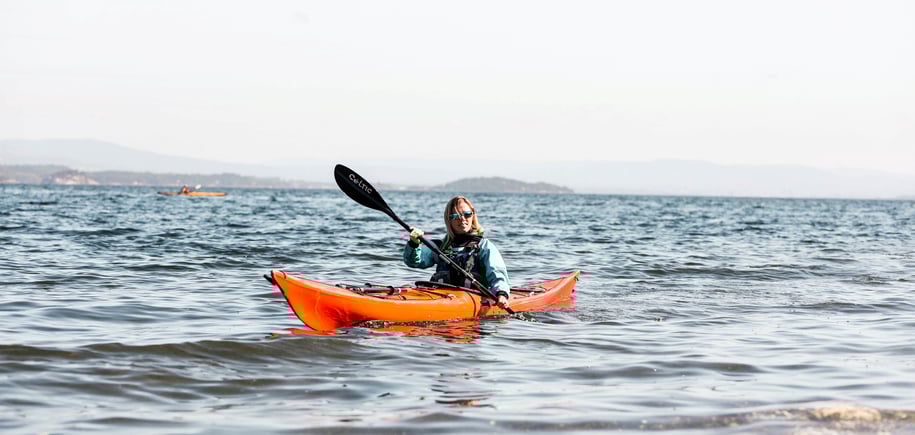 Person i rød kajakk på fjorden