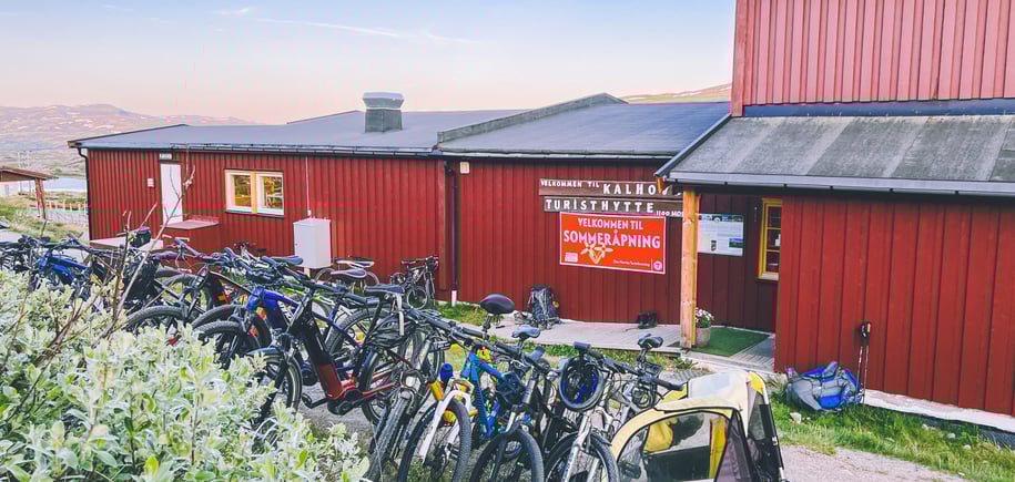 Rød hytte med mange sykler i forgrunn
