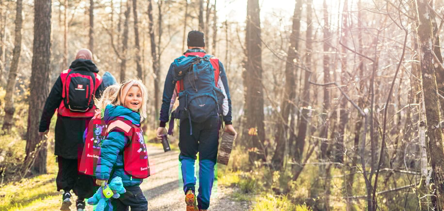 En gruppe mennesker som går på en sti i skogen