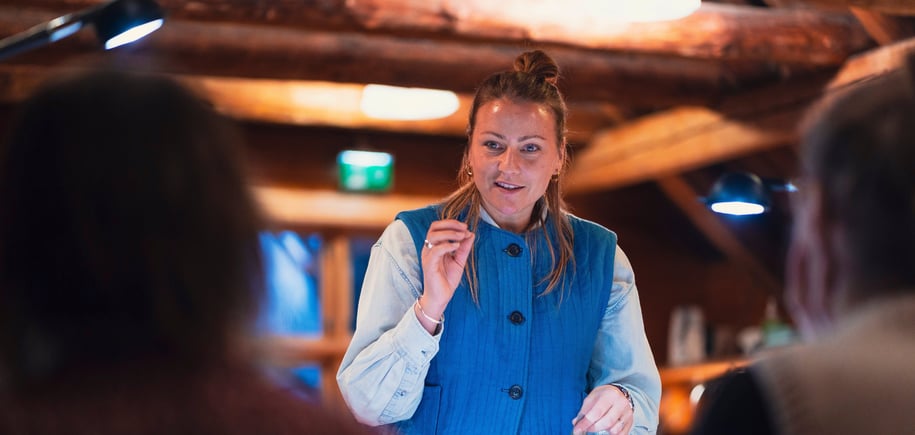 Dame i blå vest ser fokusert ut.