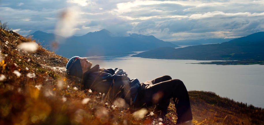 Mann ligger i lyngen og slapper av - fin utsikt