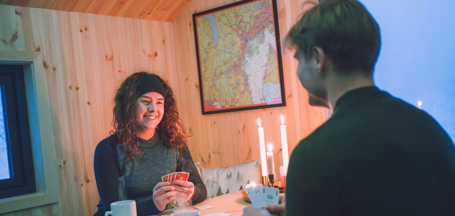 To personer spiller kort på dnt-hytte