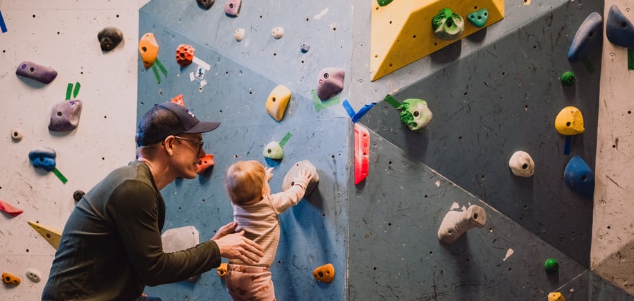 En mann og en baby som ser på en klatrevegg