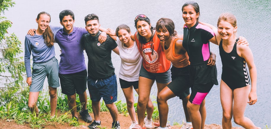 Ungdom som stor på en klippe ved et vann