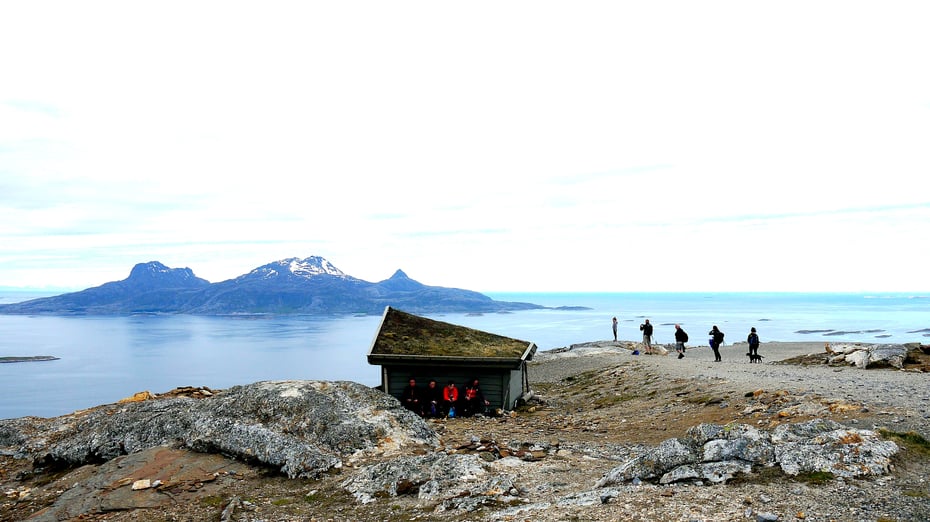 Gapahuk, litt folk og utsikt utover havet mot ei øy