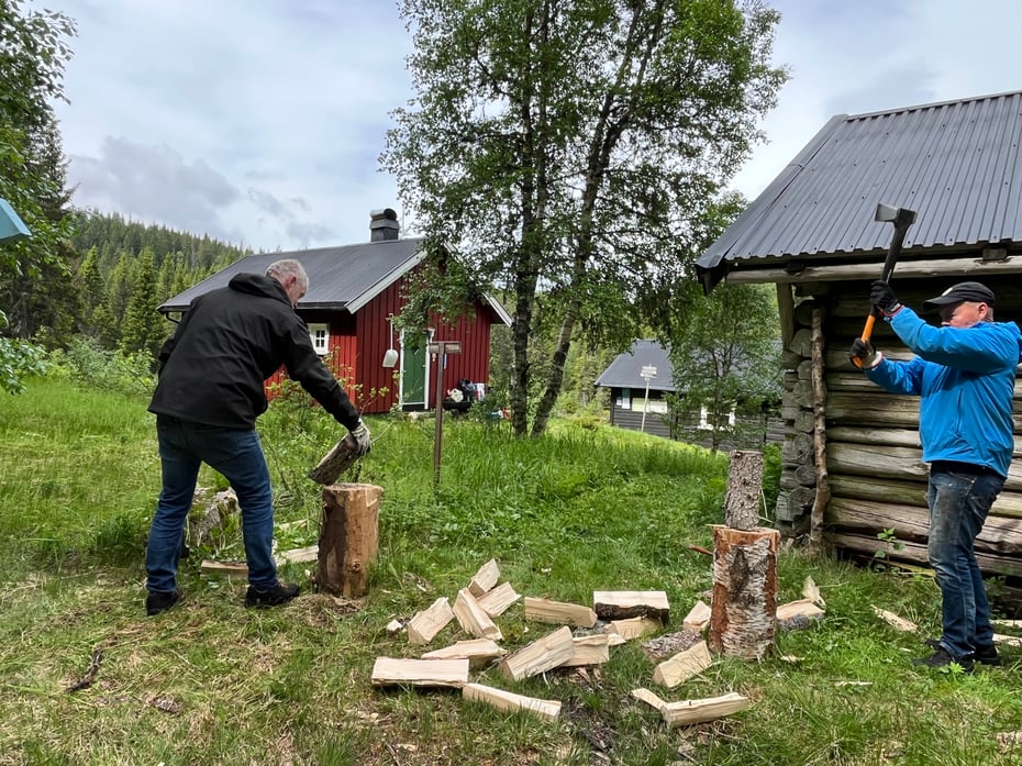 To mennesker som står å hugger ved