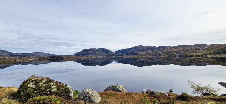 Stille vann og fjell i bakgrunnen
