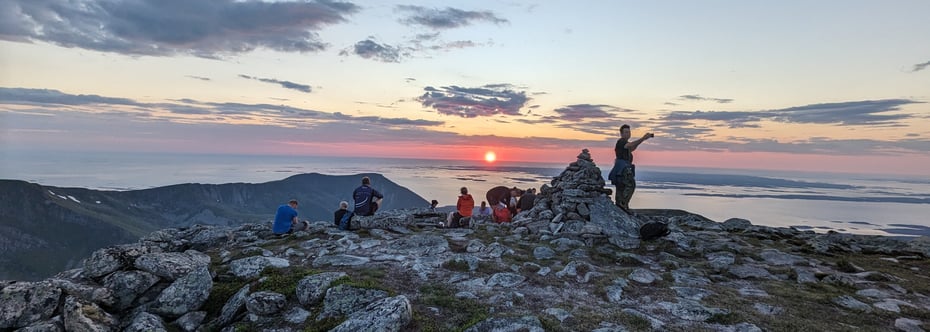 På toppen av fjellet i solnedgang 