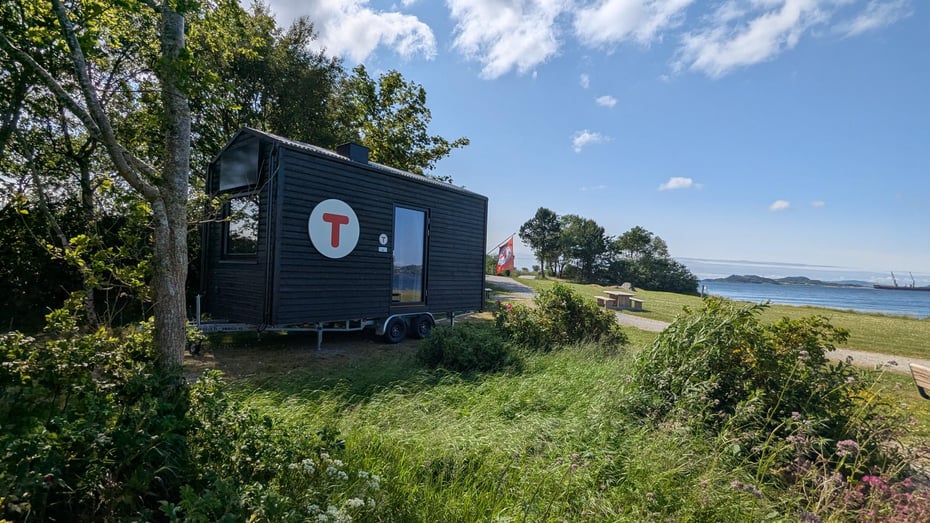 DNT-hytte på hjul parkert ved strandlinje