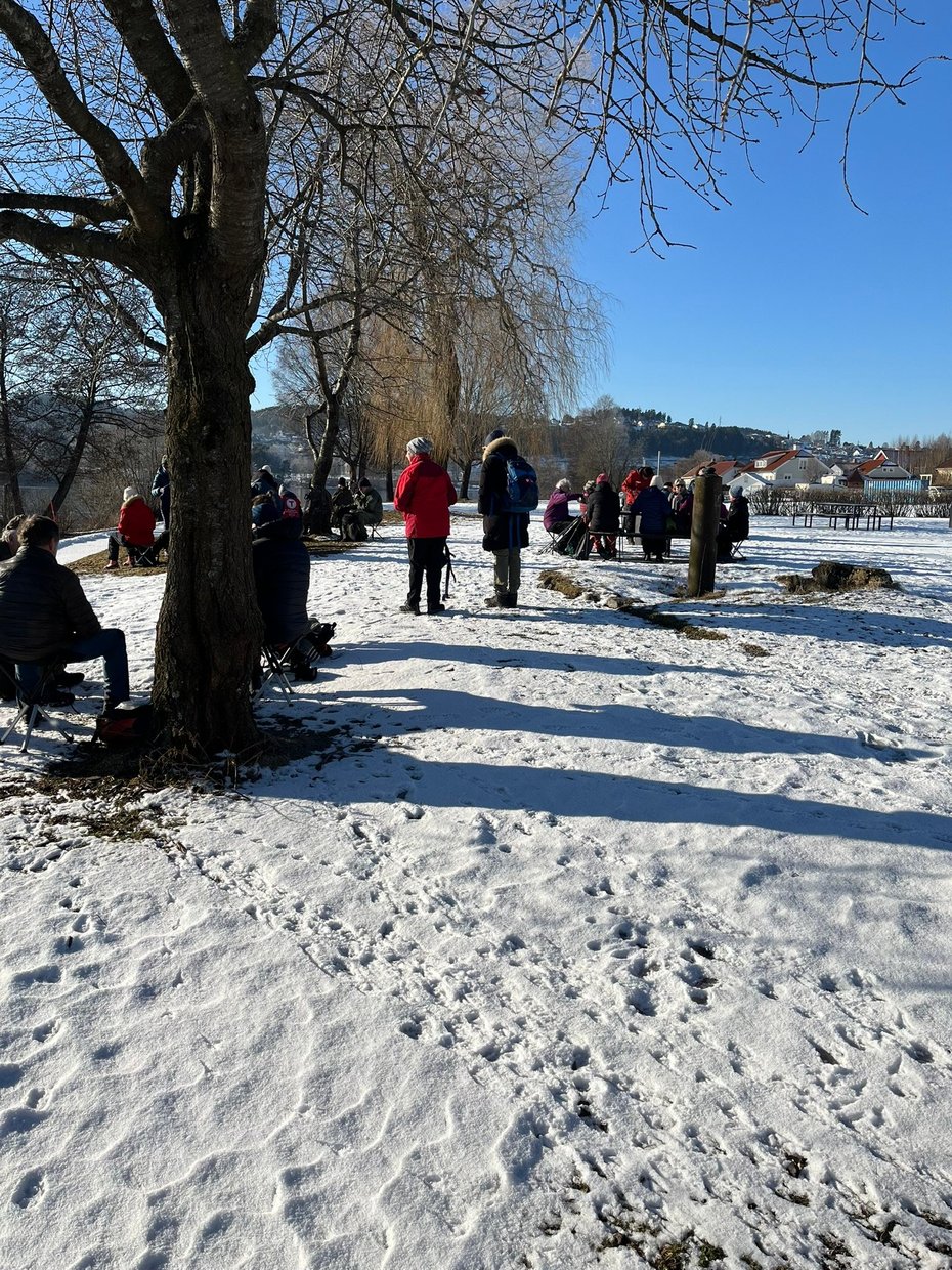 Mennesker står under et tre, det er snø på bakken