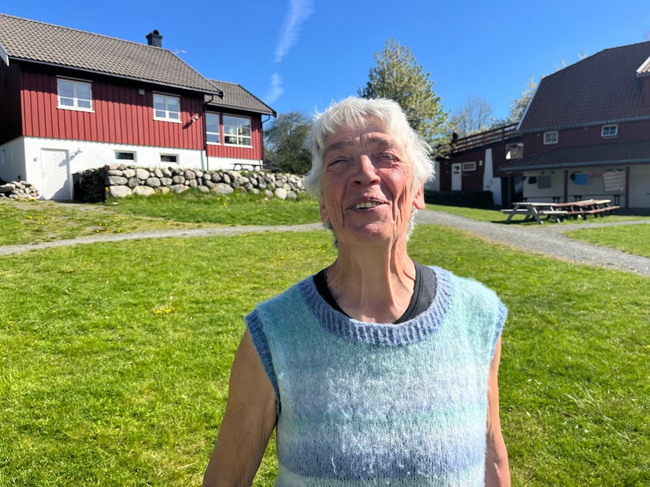 Kvinne foran hytteanlegg