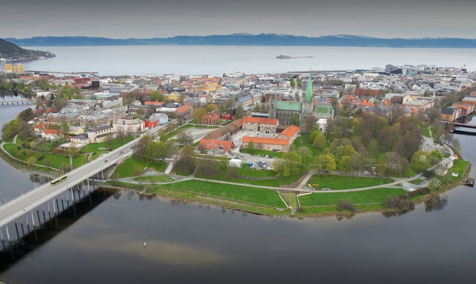 Et dronebilde av halvøya som Trondheim sentrum ligger på, sett ovenfra, med Elgeseter bru strekkende ut i nederste venstre hjørne, og fjorden synlig bak halvøya.