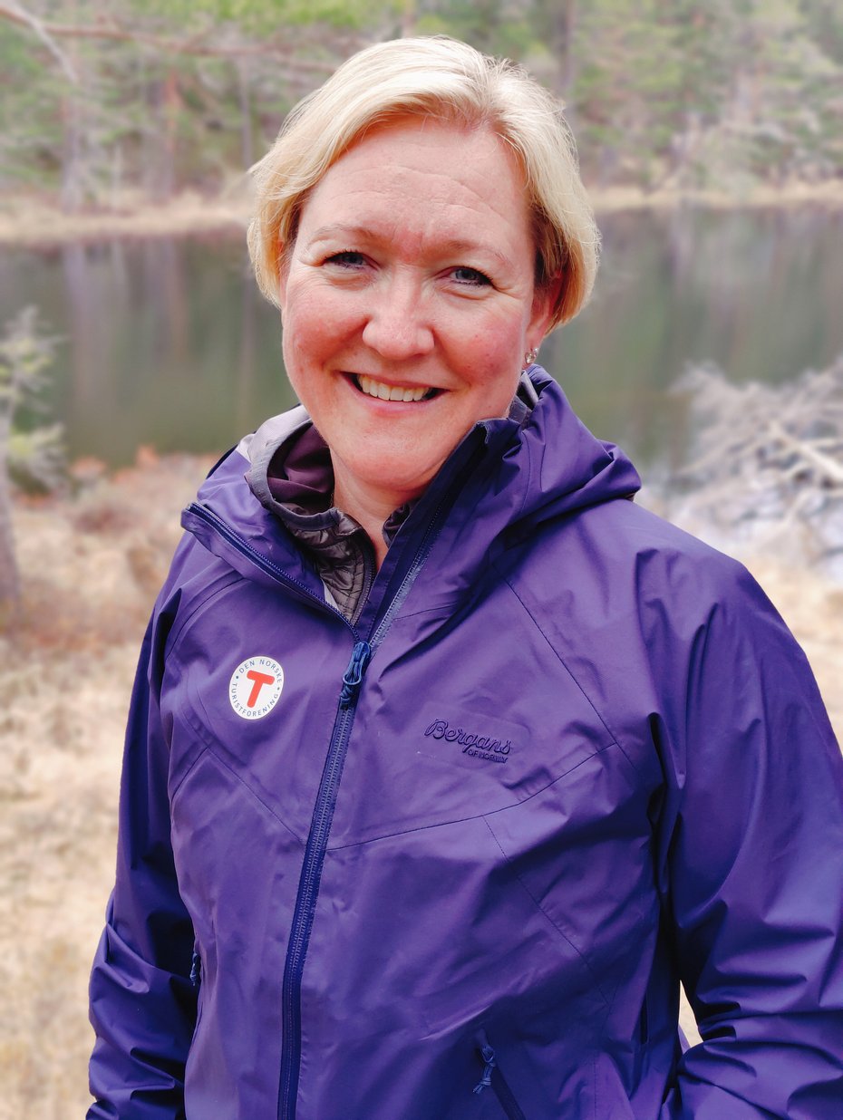 Kvinne i lilla jakke som smiler