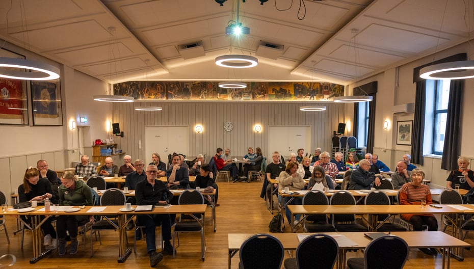 Ca 40 personer samlet i en konferansesal med klasseromsoppsett