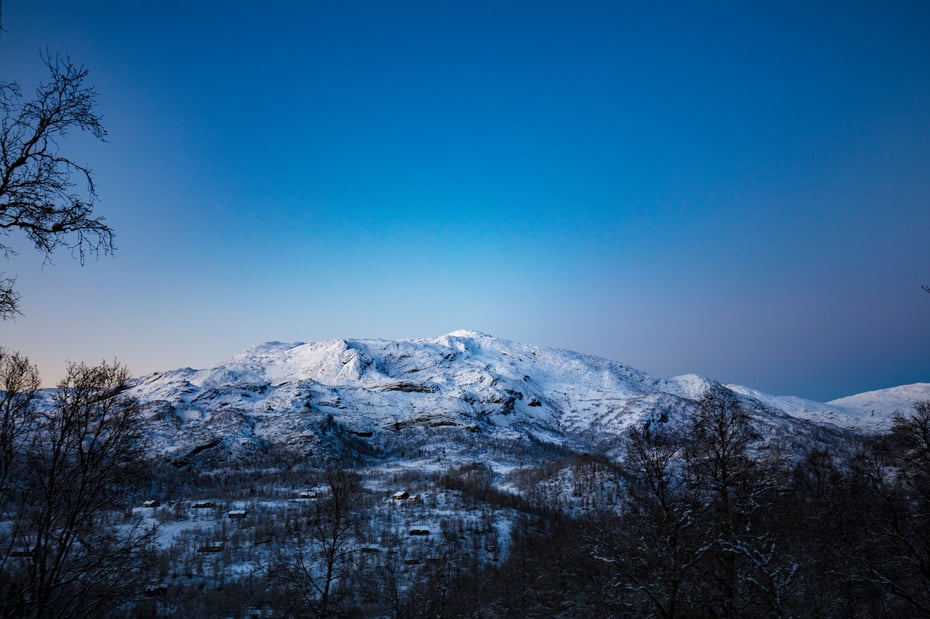 Snøkledd fjell under åpen stjernehimmel.