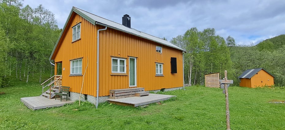 Gul hytte med grønn gresslette