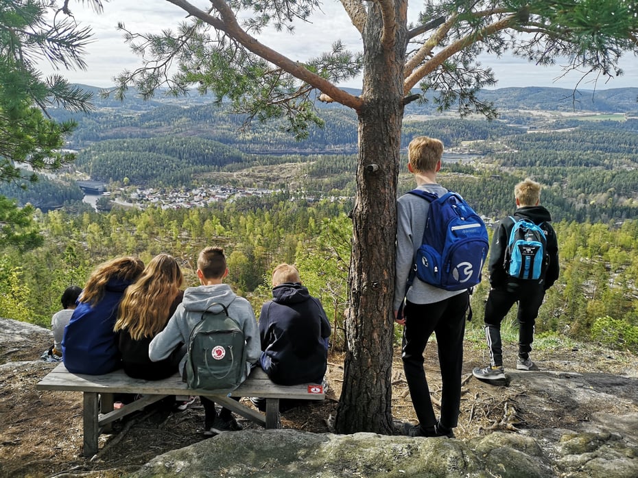Ungdommer sitter på benk og ser på utsikten.