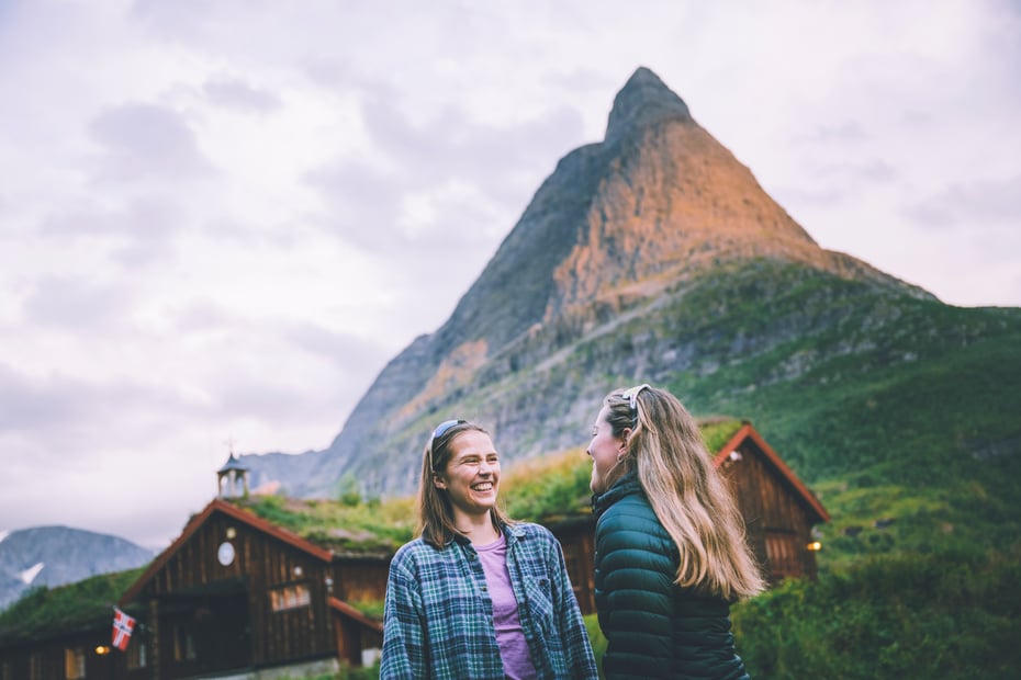 Innerdalshytta med Innerdalstårnet i bakgrunnen og turister i forgrunn