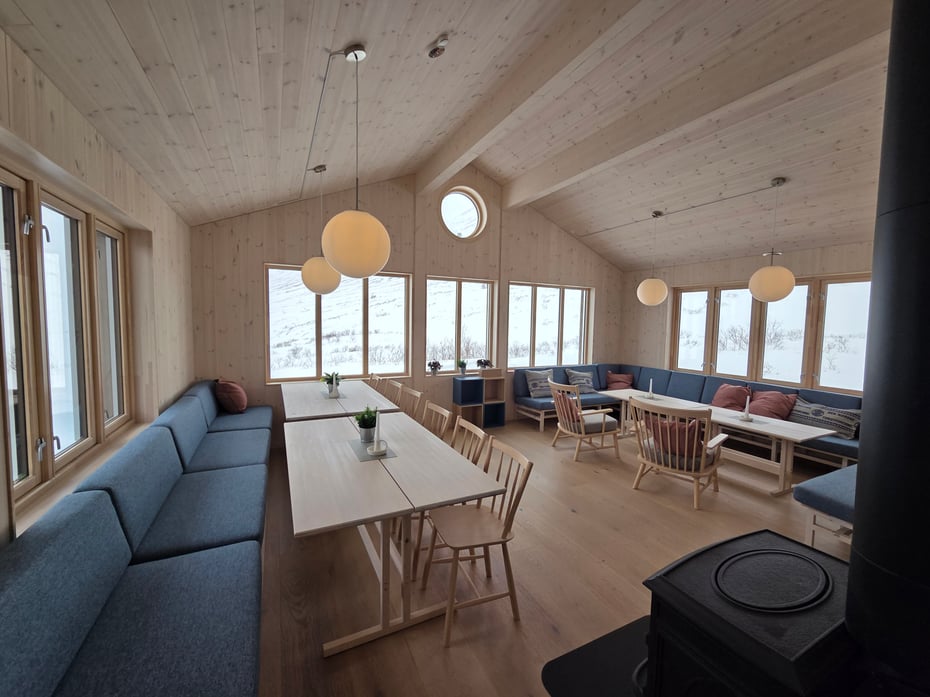 stue med møbler og vinduer med utsikt ut mot fjellet