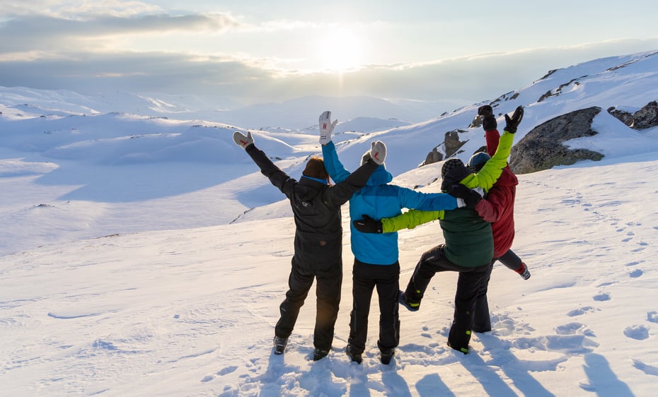 Fire personer holder rundt hverandre og jubler.