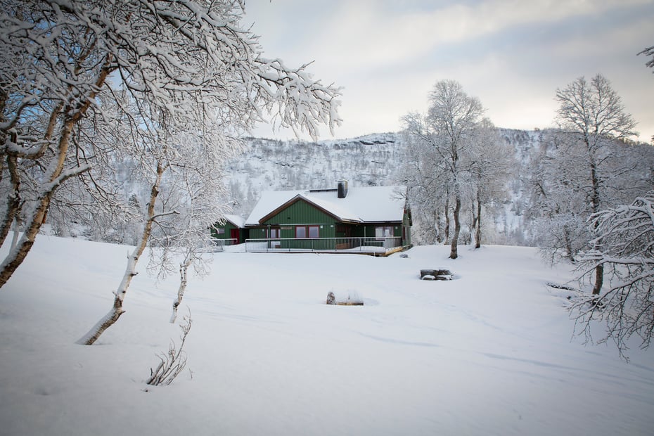 Hytte i snødekt landskap.