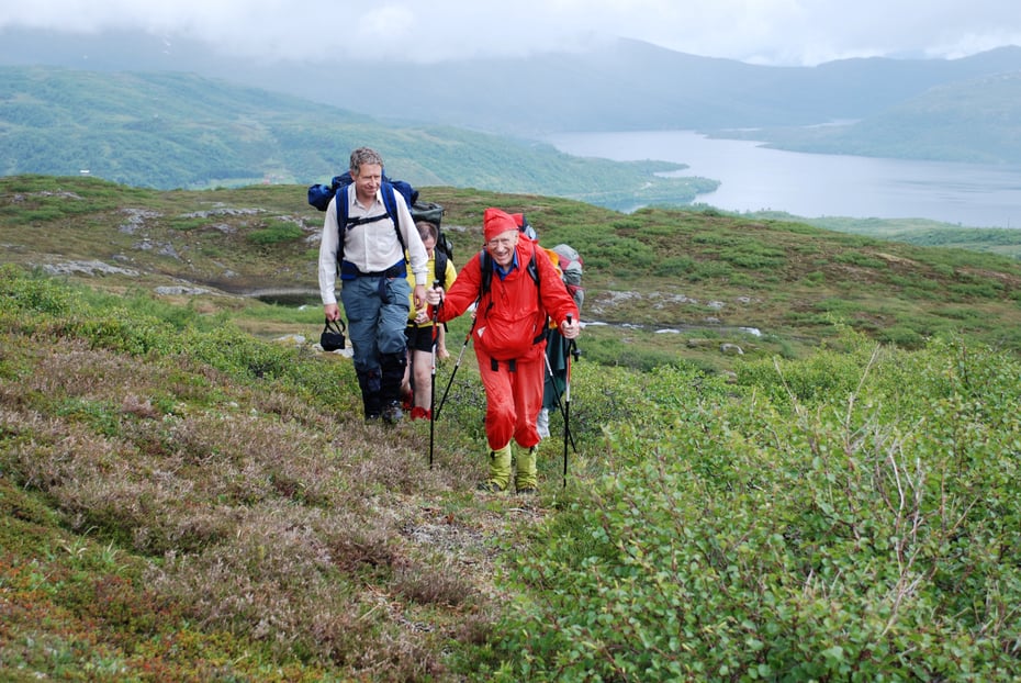 En eldre mann går på tur sammen med andre voksne i gruppe.