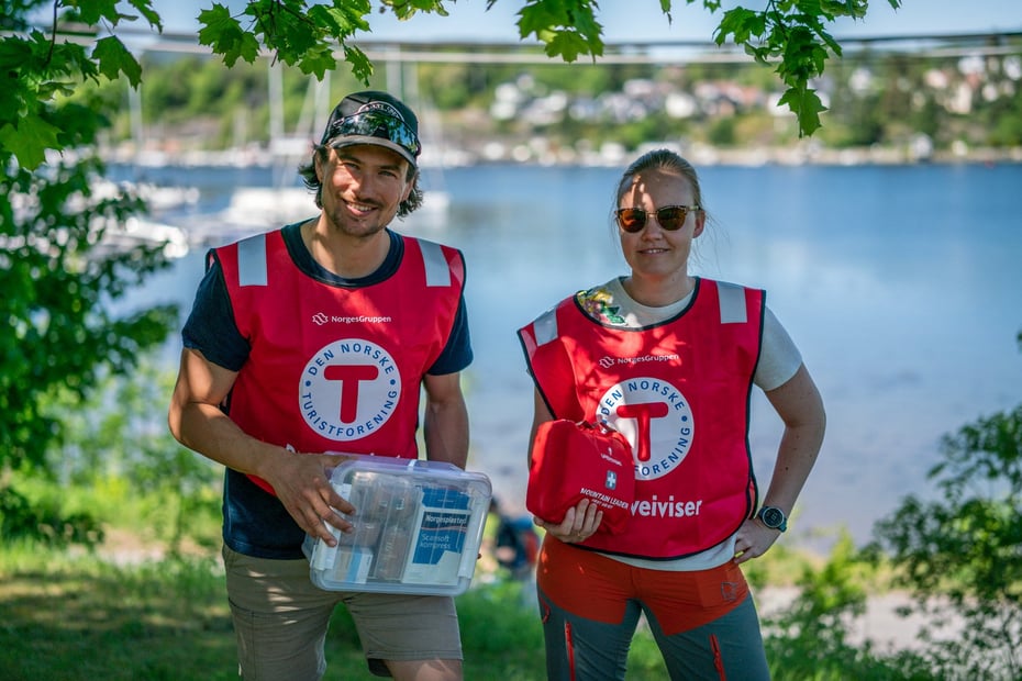 To smilende personer med rød DNT-vest.