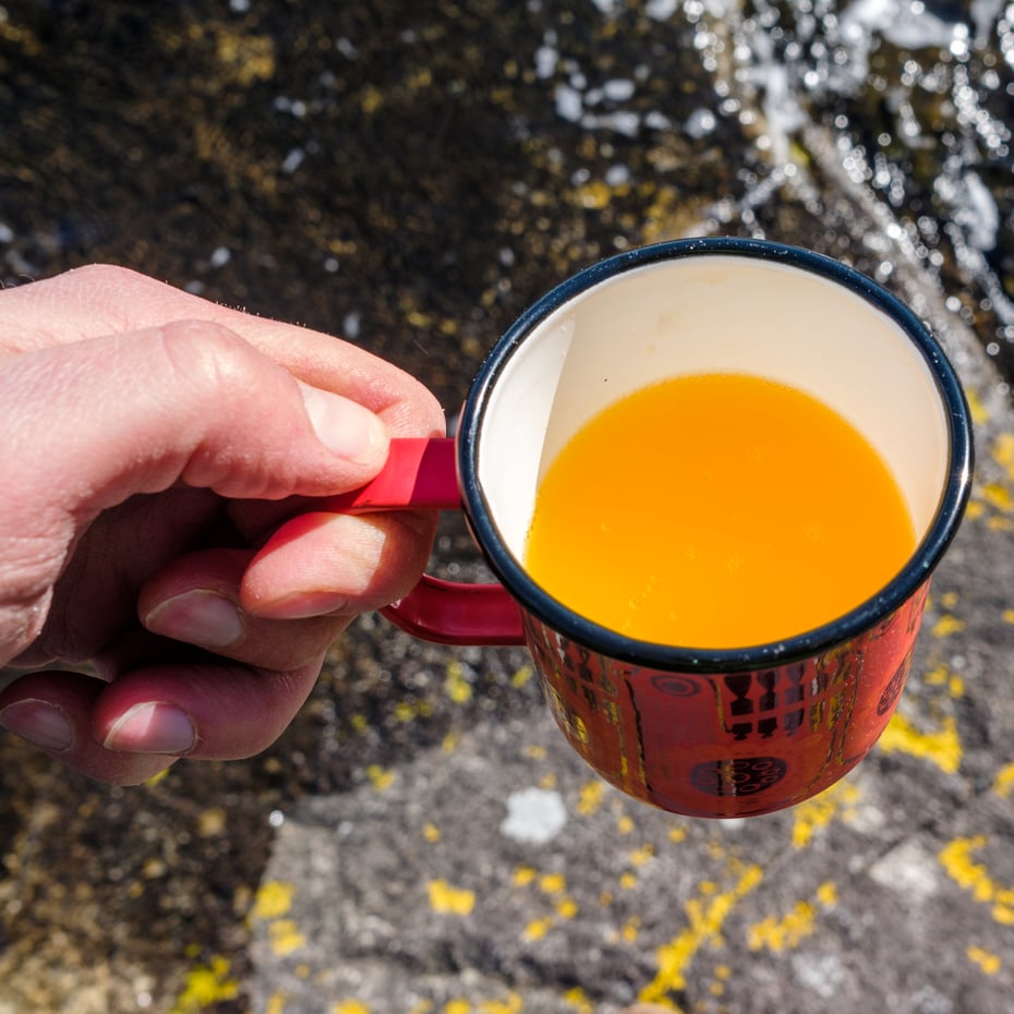 Grille pølser på gassbrenner og drikke solo på en holme i Ryfylke. Kystpåske, påske, rast.