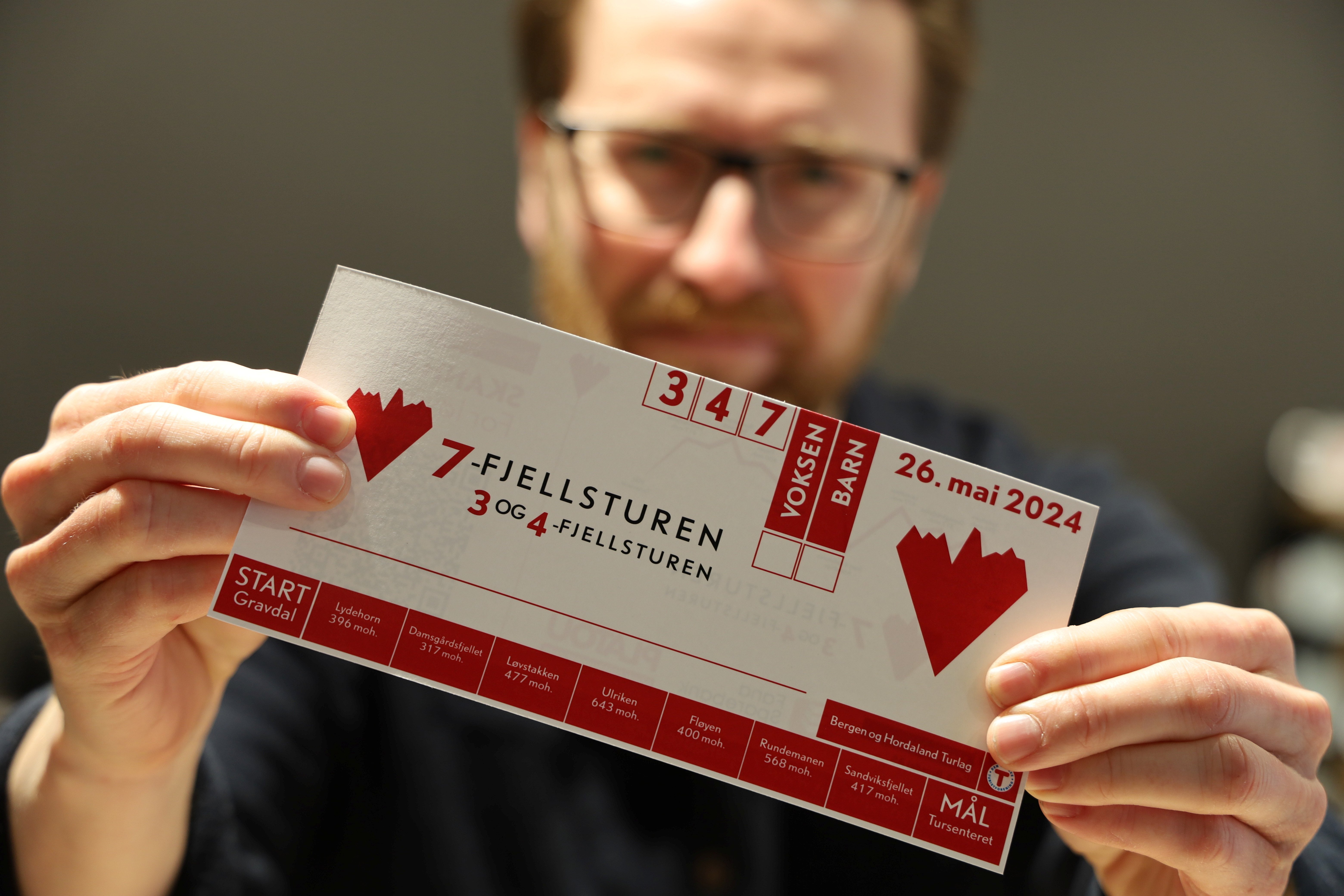 Mann viser frem startkort til 7-fjellsturen.