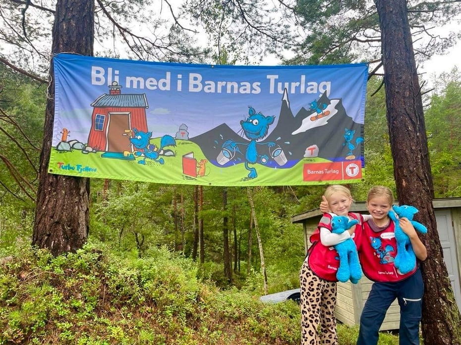 To barn med turbo bamse foran Barnas Turlag Banner