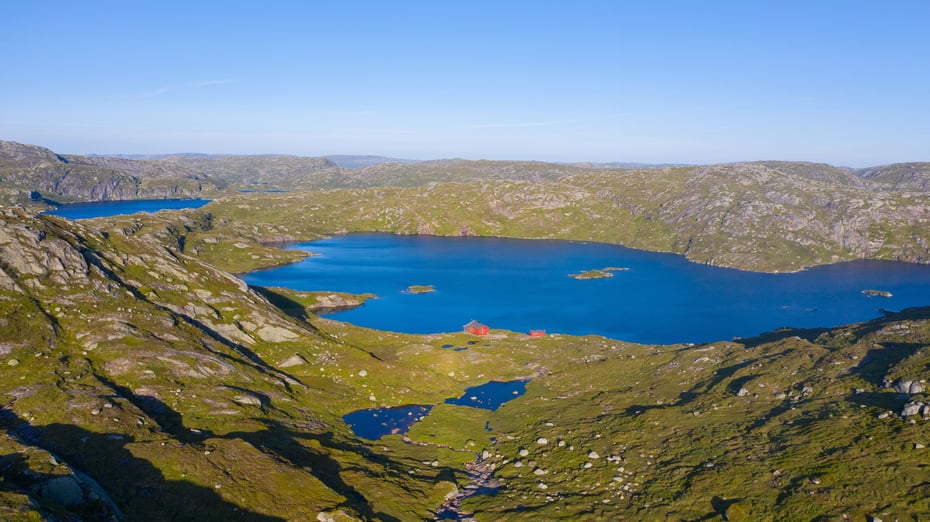 Rød hytte i fjellandskap