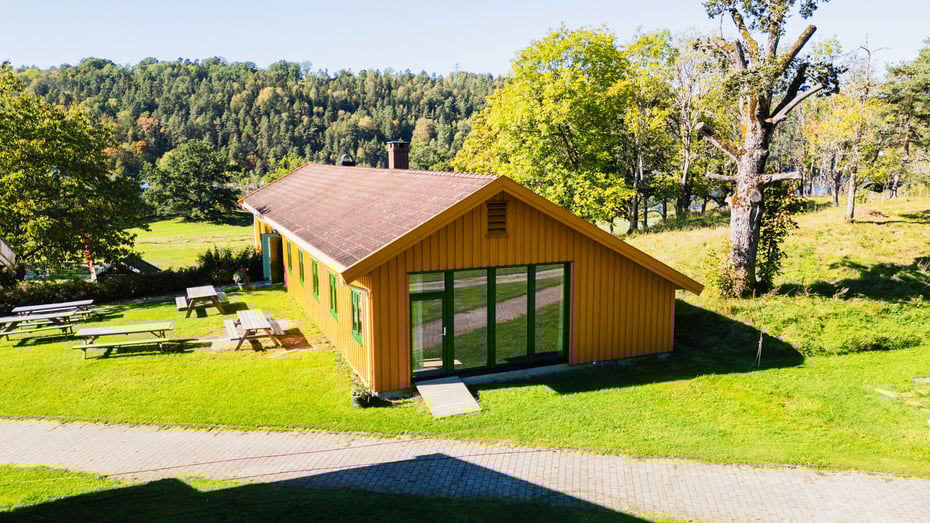 Bilde av gult hus med grønne omgivelser