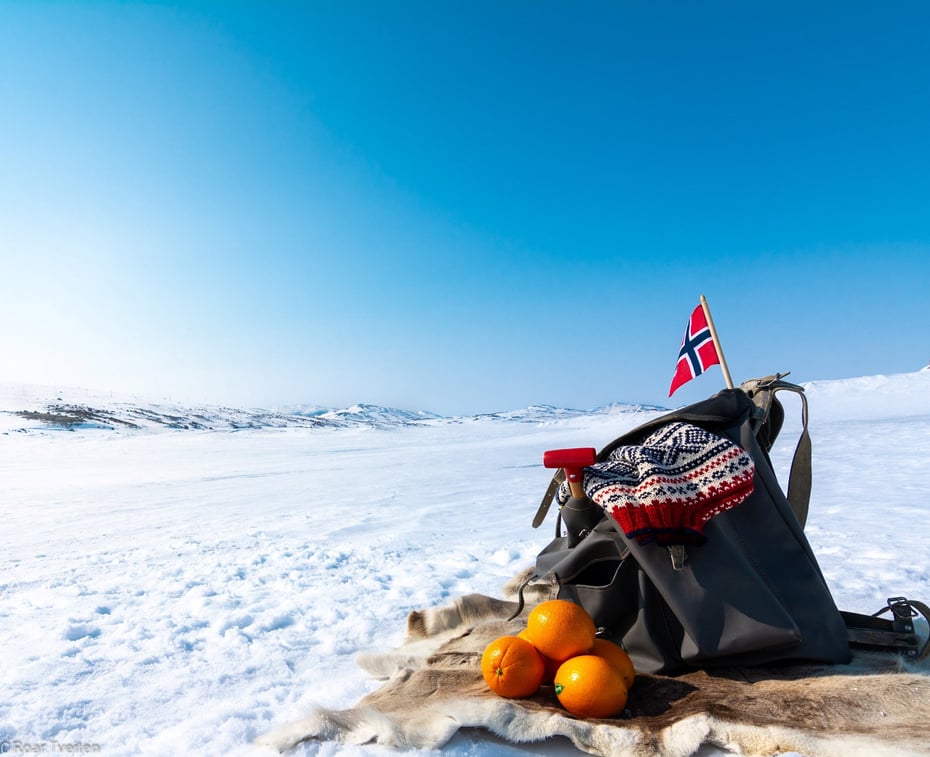 Påskestemning på Hardangervidda med tursekk, appelsin og det norske flagget.