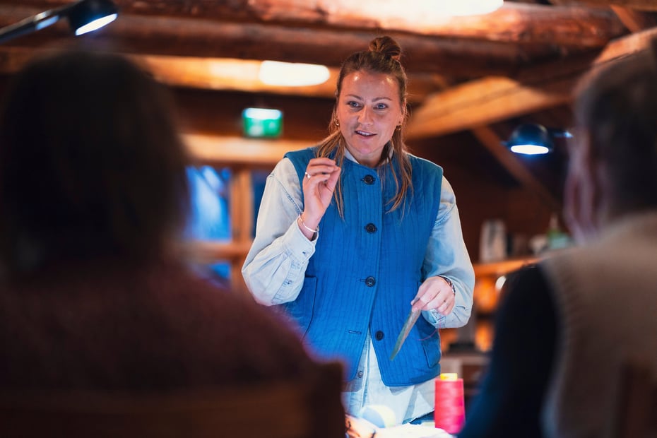 Dame i blå vest ser fokusert ut.