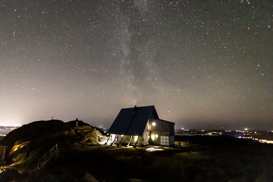Hytte på fjellet under stor stjernehimmel