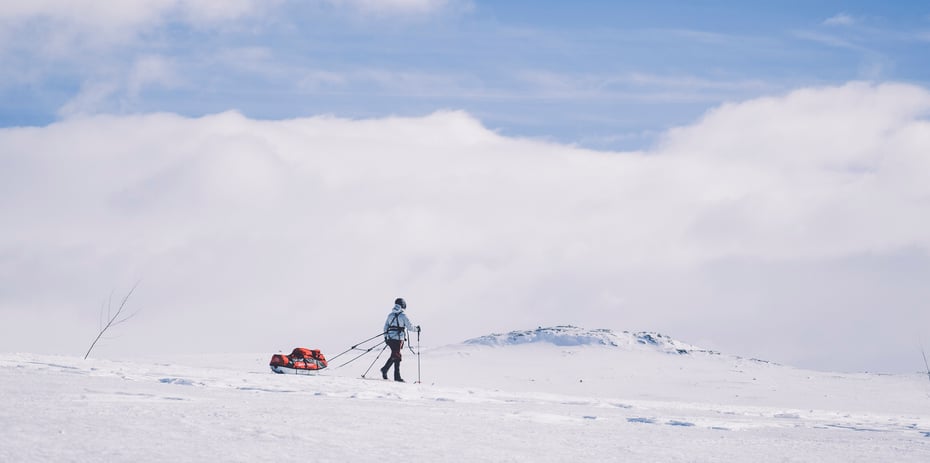 Skiløper med pulk i vinterfjellet