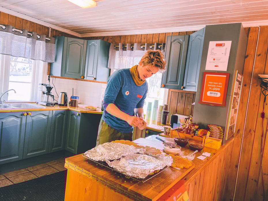 Gutt som steker vafler på en turisthytte