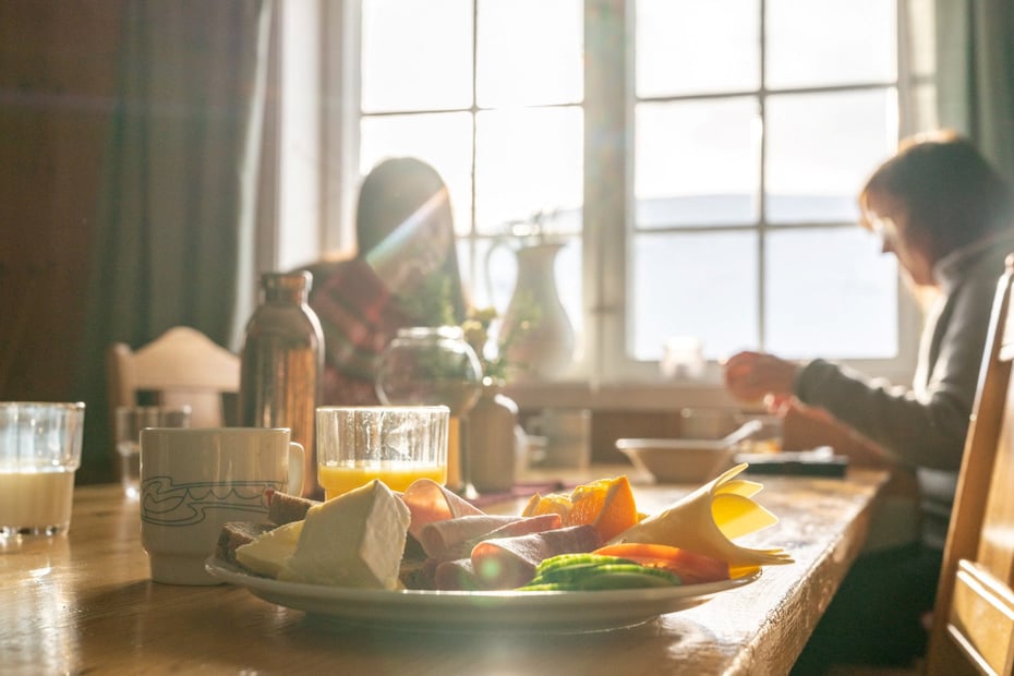 solfylt rom hvor det står en tallerken med brød og pålegg. 