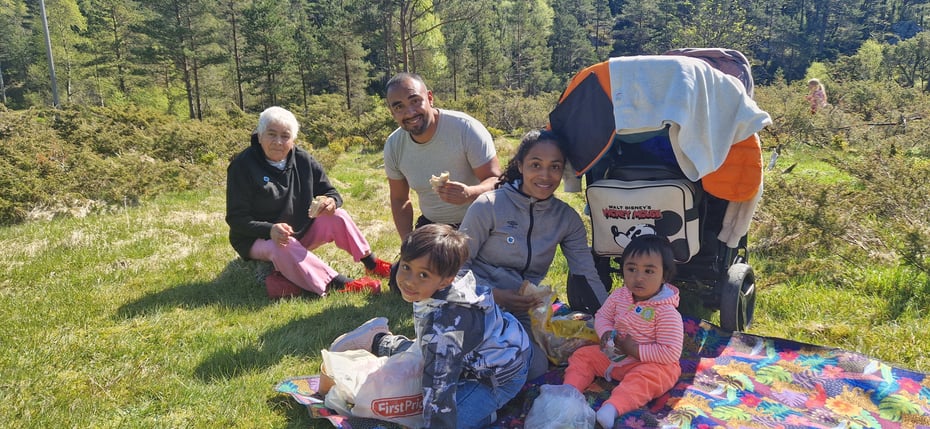 En colombiansk familie smiler i gresset.